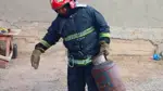 Пожарный несет газовый баллон